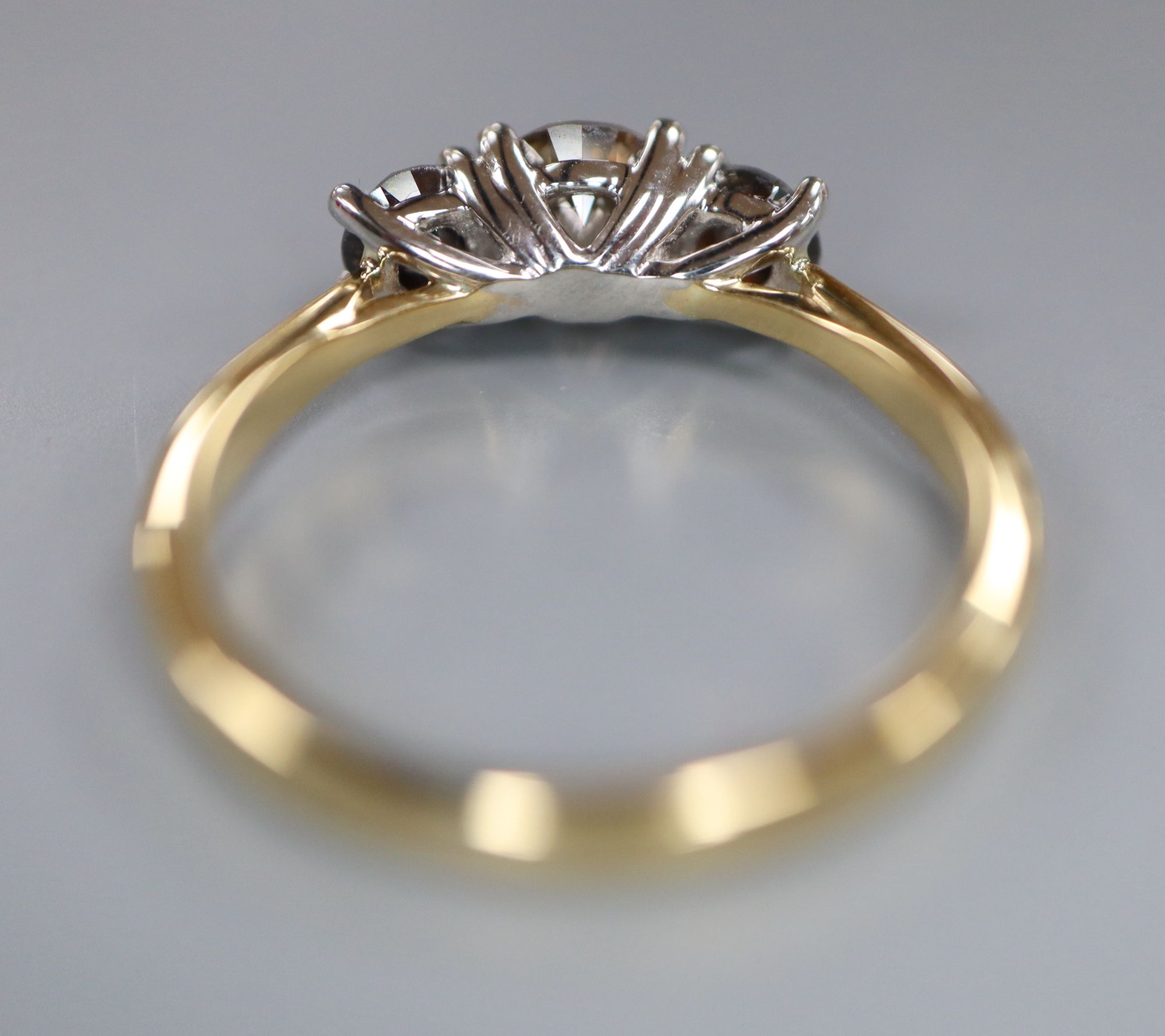 A modern 18ct gold and platinum, three stone two colour diamond set ring, size M, gross weight 3.5 grams.